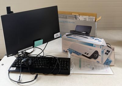 un écran d'ordinateur, un clavier, une souris et d'autres objets posés sur la table