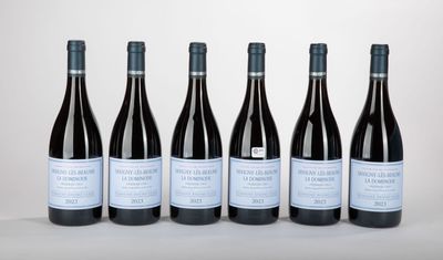 six bouteilles de vin sont alignées sur une table