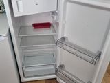 an open refrigerator with its door open on a kitchen floor
