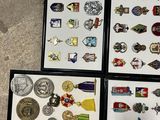 four framed pictures of medals and pins on a floor