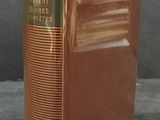 an old book sitting on top of a table next to a black background