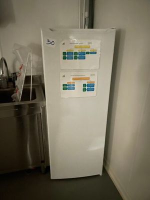 un réfrigérateur blanc dans un coin d'une cuisine équipée d'un évier