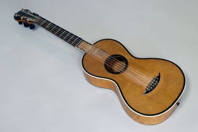 une guitare acoustique posée sur une surface blanche, avec un fond blanc