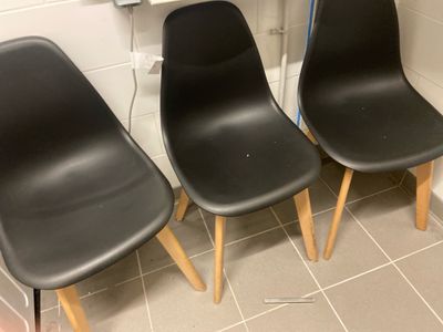 trois chaises noires alignées devant un lavabo
