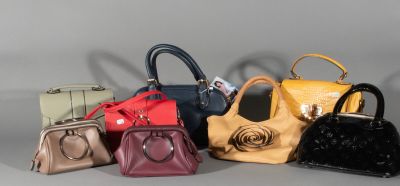 several purses are lined up in a row on a gray surface
