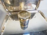 un plateau en argent sur lequel est posée une tasse en argent
