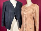 two women ' s jackets on a mannequin stand against a red wall