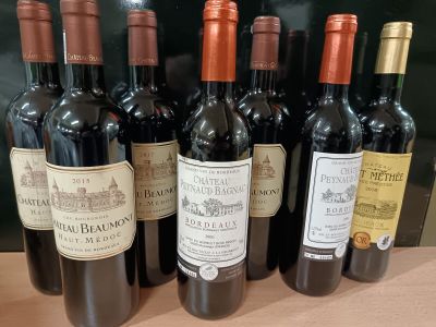 plusieurs bouteilles de vin rouge sont alignées sur une table
