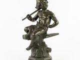 statue en bronze représentant un homme assis sur un rocher, avec un chat sur le dos