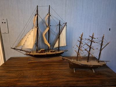 deux maquettes de bateaux posées l'une à côté de l'autre sur une table