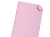un gros plan sur un cahier rose orné d'un bouton