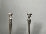 pair of silver candlesticks on a grey background