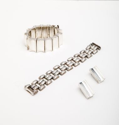 silver metal bracelet with a clasp and a clasp on a white surface