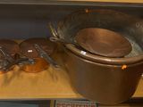des casseroles et des poêles posées sur une étagère dans un magasin