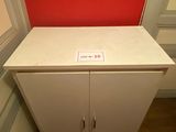 une armoire blanche avec un mur rouge en arrière-plan