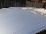 a white car parked in front of a brick wall