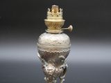 un vase en argent avec un couvercle en or posé sur une table noire