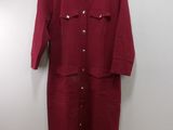 une robe-chemise rouge suspendue à un cintre accroché au mur