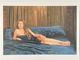 une photo d'une femme allongée sur un lit, vêtue d'une robe bleue