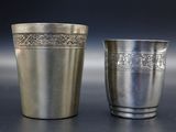 deux tasses en argent posées l'une à côté de l'autre sur une table