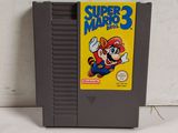 a close up of a nintendo super mario 3 game on a white surface