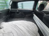 someone is sleeping in the back of a car with a white blanket
