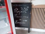 a chalk board with writing on it in front of a refrigerator