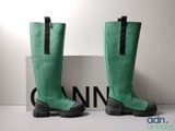 une paire de bottes vertes posée sur une boîte à côté d'un panneau