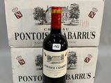 une bouteille de vin posée à côté de deux cartons de vin