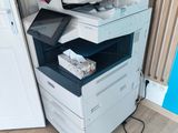 a multi - function printer sitting on the floor next to a door