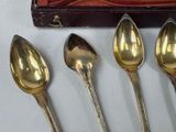 three silver spoons and two silver spoons sitting on a table