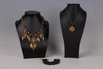 un mannequin noir portant un collier et des boucles d'oreilles