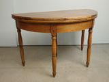 une petite table en bois au plateau incurvé, posée à même le sol