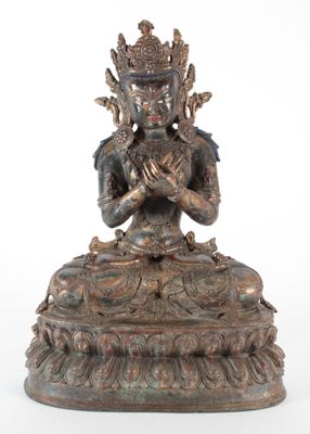 une statue antique en bronze représentant une femme assise sur un lotus