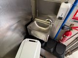 a toilet and a trash can in a public restroom