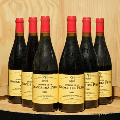 six bottles of red wine are lined up on a wooden barrel