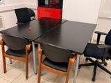 a black table and chairs in a room with a red cabinet