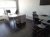 a desk and chair in a room with a large screen on the wall