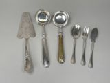 five silver spoons and two silver spoons on a table