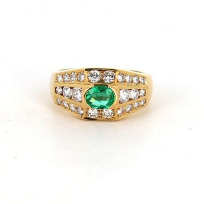 gros plan d'une bague avec une pierre verte entourée de diamants
