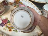 a person holding a cup and saucer on a table