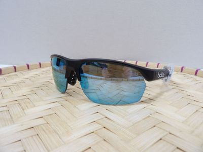 un gros plan sur une paire de lunettes de soleil posée sur un panier tressé