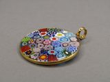 un gros plan d'un petit pendentif en verre orné de fleurs