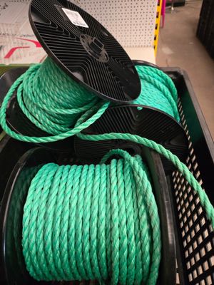 un tas de corde verte posé sur un panier noir