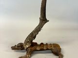 sculpture of a lizard on a branch on a white background
