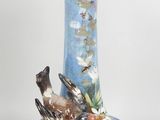 a blue vase with a bird on it on a table