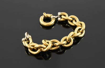 a close up of a gold chain bracelet on a black surface
