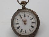 a silver pocket watch with roman numerals on the face
