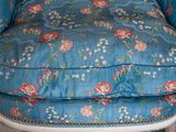 a blue chair with a floral pattern on the back of it