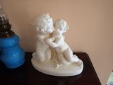 une petite statue représentant un garçon et une fille assis sur une table